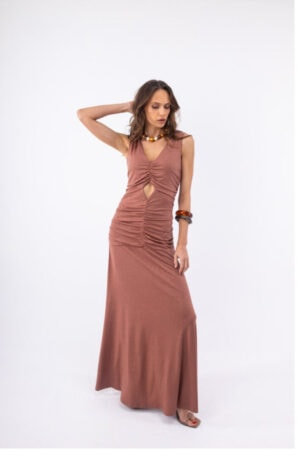 Γυναίκα φοράει μακρύ φόρεμα με κοψίματα και αξεσουάρ, ιδανικό για καλοκαιρινές εμφανίσεις.